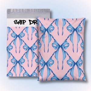 May include: A rectangular poly mailer shipping bag featuring a repeating pattern of light blue bows on a soft pink background. The top portion of the bag includes a white horizontal strip with the black text SHIP DR printed in a stylized font.