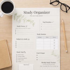 Peut inclure: Une tasse en céramique blanche avec une anse noire et le texte "But First, Coffee" dans un style manuscrit. La tasse est posée sur une surface blanche. La tasse mesure environ 10 cm de haut.