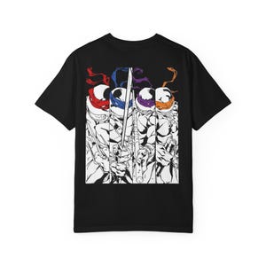 Könnte beinhalten: Schwarzes T-Shirt mit einer Grafik der Teenage Mutant Ninja Turtles. Das Design zeigt die vier Schildkröten in einer Schwarz-Weiß-Illustration, jede mit einer andersfarbigen Maske: rot, blau, lila und orange.