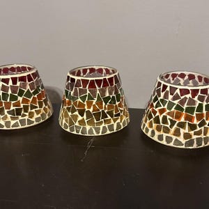 May include: A set of three ceramic mugs with a speckled, matte finish. The mugs are in shades of cream, light gray, and dark gray. Each mug has a simple, minimalist design, perfect for coffee or tea.