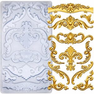 May include: A rectangular clear silicone mold featuring various intricate scrollwork and floral relief patterns, displayed alongside several finished gold-colored decorative ornaments that match the shapes within the mold's cavities.