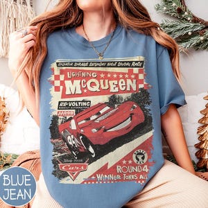May include: Blue jean-colored t-shirt featuring a graphic of Lightning McQueen from the Disney Pixar Cars movie. The design includes text that reads "Radiator Springs Saturday Night Special Race" and "Winner Takes All."