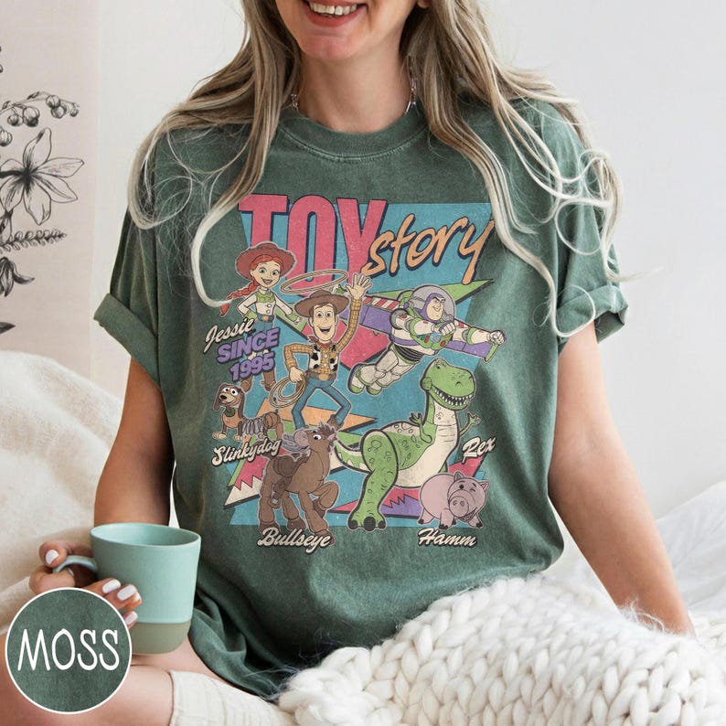 May include: Green t-shirt with a Toy Story graphic featuring Woody, Buzz Lightyear, and Rex. The text "Toy Story" and "Jessie Since 1995" are displayed. The shirt has a vintage, distressed appearance.