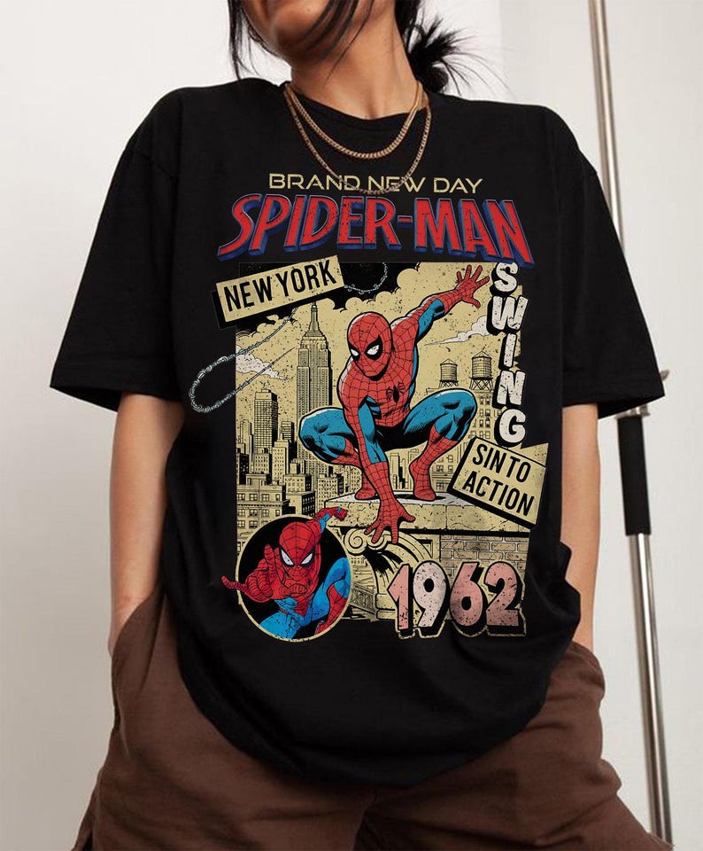 Puede incluir: Camiseta negra con un dise&ntilde;o vintage de Spider-Man. El dise&ntilde;o incluye las palabras "Brand New Day", "Spider-Man" y "New York", junto con una ilustraci&oacute;n de Spider-Man y el a&ntilde;o 1962.