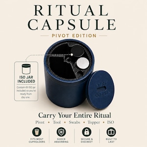 May include: A dark blue cylindrical Ritual Capsule Pivot Edition container with a removable lid featuring the text PORT MILLER. The interior has partitioned compartments containing a black and a silver circular item, with an ISO jar included.