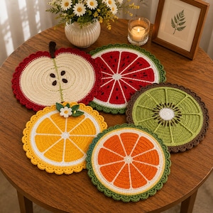 May include: A set of five round, crocheted coasters featuring fruit designs: an apple, a watermelon slice, a kiwi, and two citrus slices in yellow and orange. Each coaster has a scalloped edge and detailed stitching representing fruit segments.