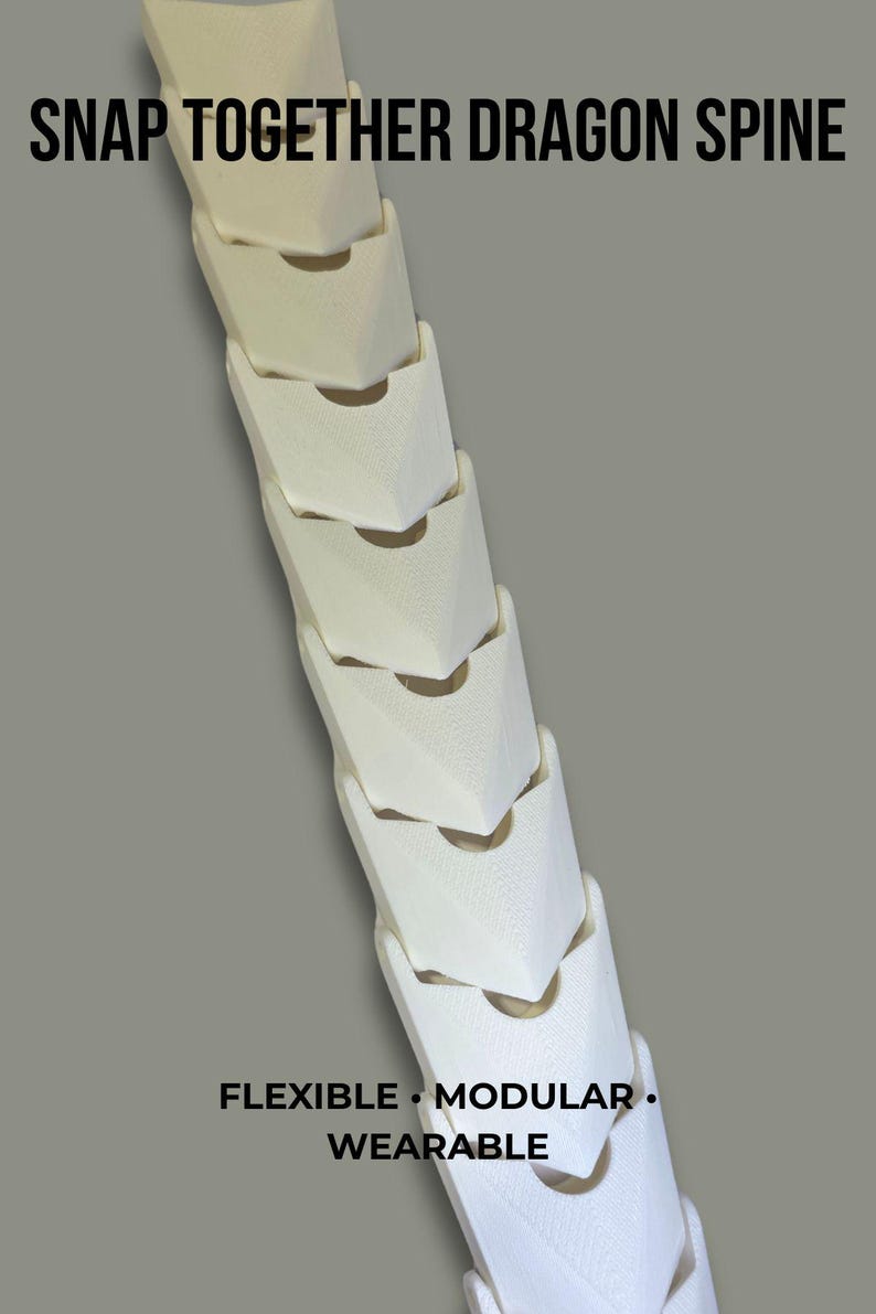 May include: A white, modular, snap-together dragon spine featuring a series of interlocking, textured segments. The text SNAP TOGETHER DRAGON SPINE is at the top, and FLEXIBLE &bull; MODULAR &bull; WEARABLE is printed at the bottom of this articulated piece.