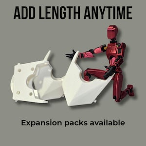 May include: A metallic red articulated action figure kneeling beside two white 3D-printed plastic components with textured surfaces. The text ADD LENGTH ANYTIME appears at the top, and the text Expansion packs available appears at the bottom.