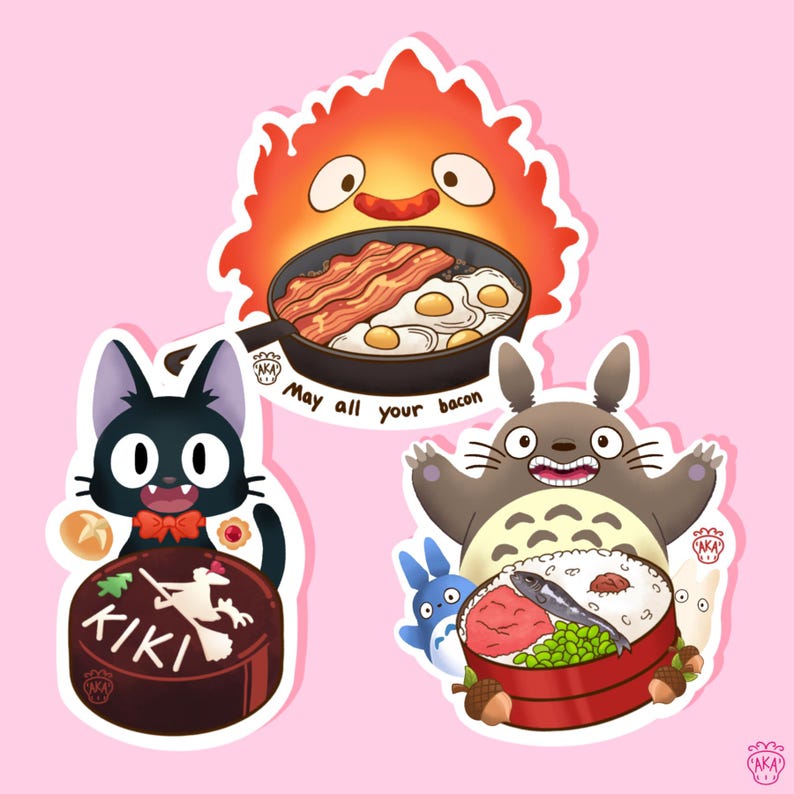 Puede incluir: Un conjunto de pegatinas de dibujos animados con personajes de pel&iacute;culas de animaci&oacute;n. Una pegatina muestra un personaje de fuego con una sart&eacute;n de tocino y huevos. Otra representa un gato negro con un pastel. La tercera muestra una gran criatura gris con un bento.