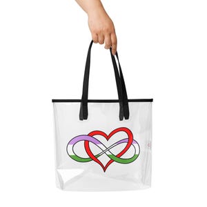 May include: Clear tote bag with black handles and trim. The bag features a heart-shaped infinity symbol in red, purple, and green. The bag is held by a hand.