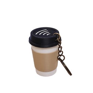 May include: A miniature coffee cup keychain with a black lid and a tan sleeve. The keychain has a bronze-colored chain and a key-shaped charm. The cup is white and appears to be made of plastic.