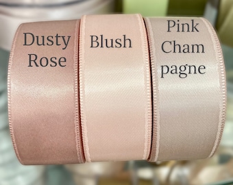 May include: Three rolls of satin ribbon in different shades of pink. From left to right, the colors are Dusty Rose, Blush, and Pink Champagne.