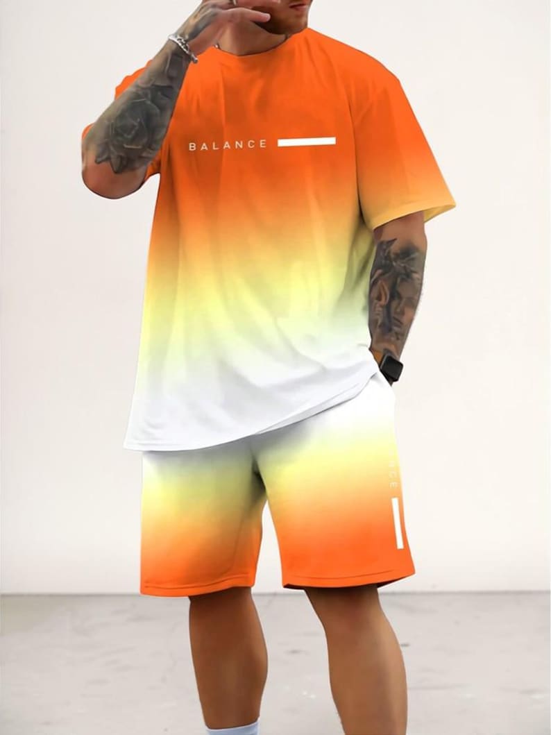 May include: Orange, yellow, and white gradient t-shirt and shorts set. The t-shirt has the word "BALANCE" printed on the chest. The shorts have a matching gradient design. A modern and stylish athletic outfit.