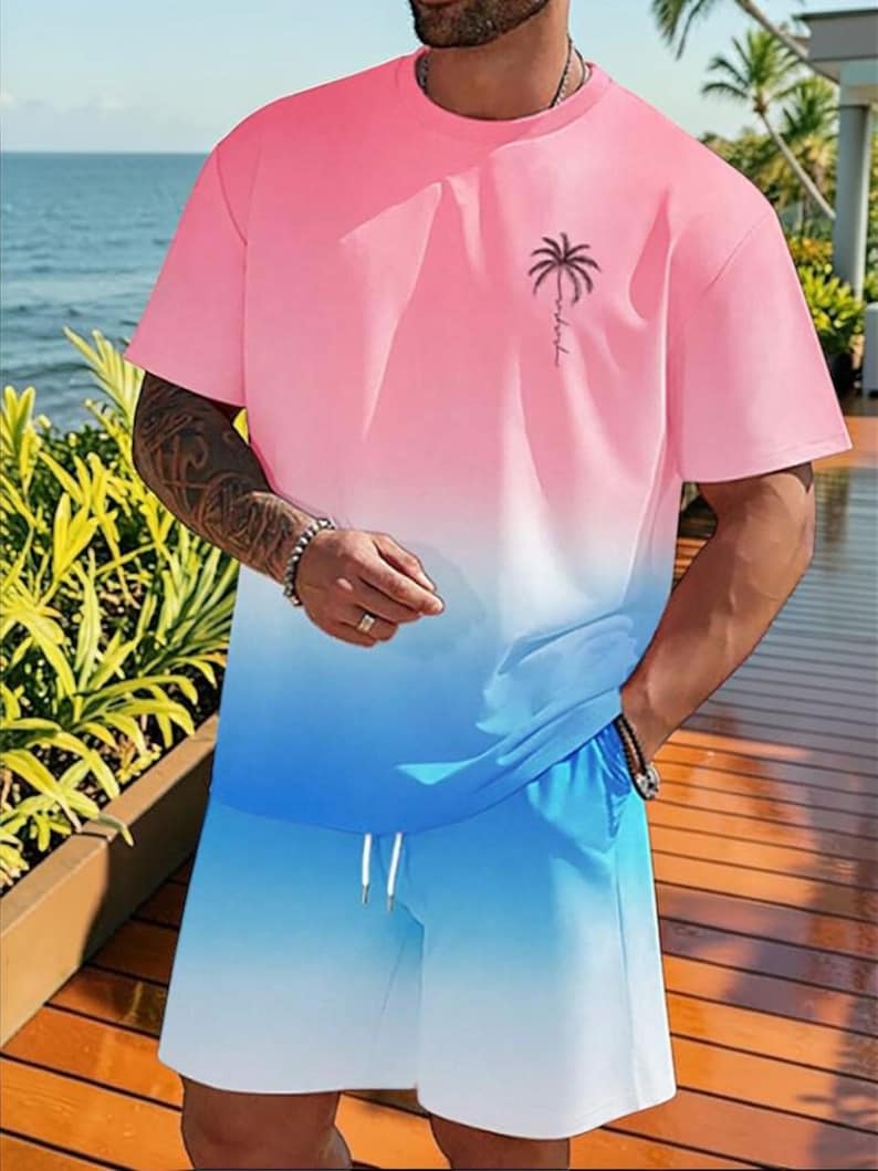 May include: A two-piece set featuring a pink and blue gradient design. The short-sleeved t-shirt has a palm tree graphic and the word "relax" printed on the chest. The shorts have a drawstring waist. The set is made of a soft, comfortable material.