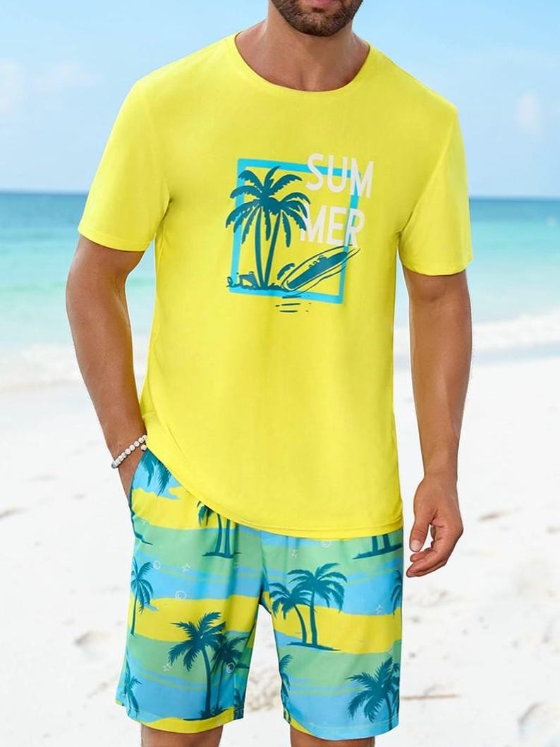 May include: Yellow crew neck t-shirt and matching shorts. The t-shirt features a blue square with a palm tree and surfboard graphic, with the word "SUMMER" printed in white. The shorts have a blue, green, and yellow striped pattern with palm trees.