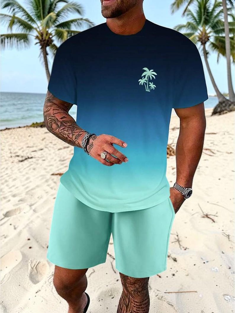 May include: A two-piece matching set featuring a gradient design. The t-shirt transitions from navy blue to turquoise, with a small palm tree graphic. The shorts are turquoise. The set is made of a soft, lightweight material.