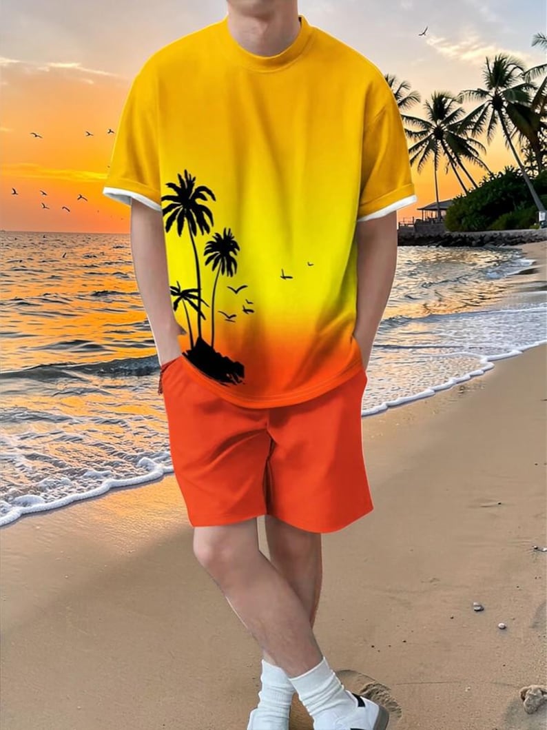 May include: A two-piece outfit featuring a yellow and orange gradient t-shirt with a palm tree graphic and orange shorts. The t-shirt has white trim on the sleeves and collar. The outfit is worn on a sandy beach with a sunset backdrop.