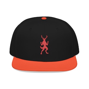 May include: Black baseball cap with a red embroidered deer-like figure on the front. The cap has a flat orange brim and a matching orange button on top. A stylish accessory for casual wear.
