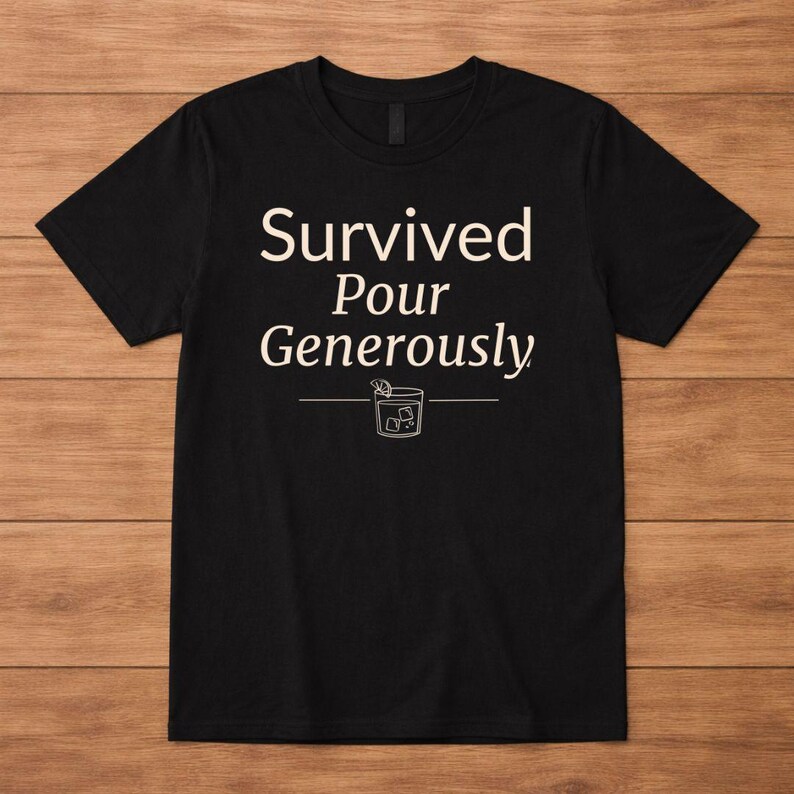 May include: Black t-shirt with the text "Survived Pour Generously" in white, above a line drawing of a cocktail. The shirt is a crew neck style.