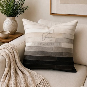 May include: A square throw pillow featuring a horizontal gradient pattern that transitions from off-white at the top to dark charcoal at the bottom. The surface is composed of stitched rectangular panels. The text THE PILLOW ART HUB is visible.