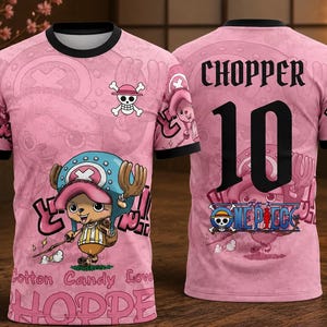 Puede incluir: Camiseta rosa con un personaje de dibujos animados y un logo de calavera. La camiseta tiene ribetes negros y el número 10 en la espalda. El texto incluye "Cotton Candy Love" y "Chopper".