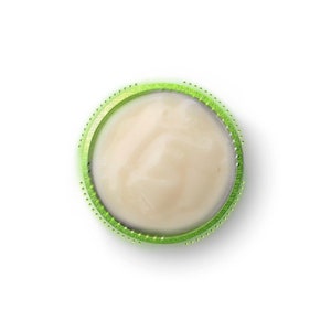 May include: A close-up of a round, white, creamy substance in a green container with a dotted rim.