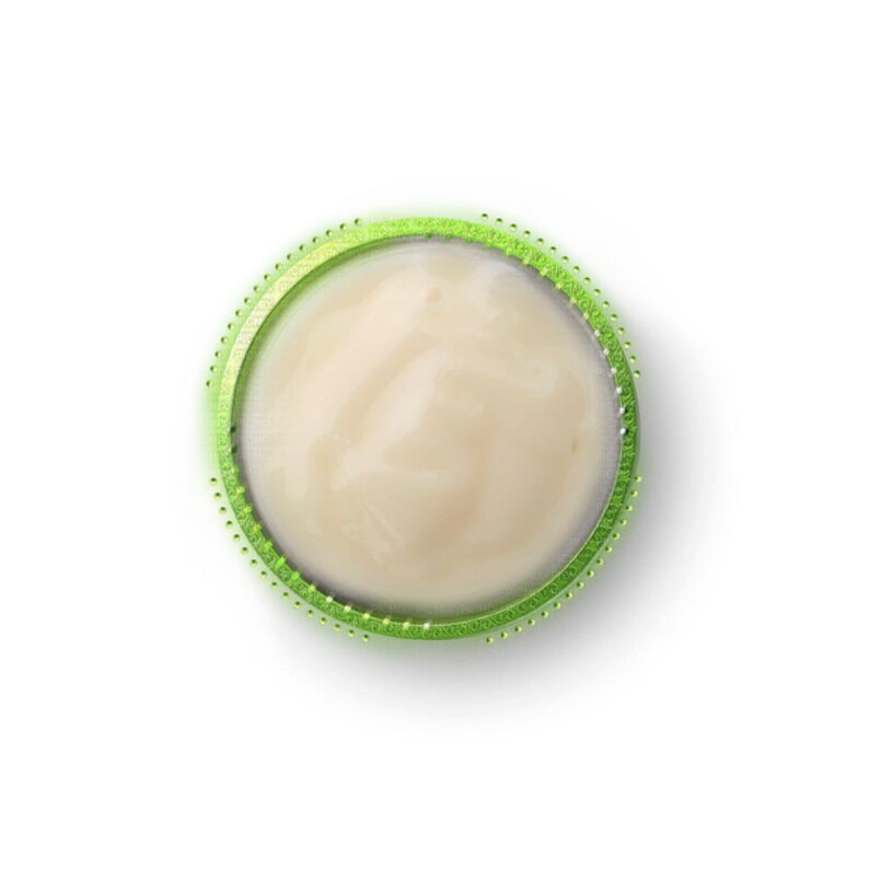May include: A close-up of a round, white, creamy substance in a green container with a dotted rim.