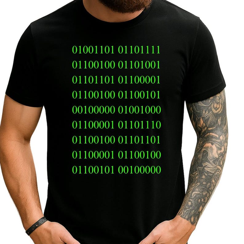 May include: Black t-shirt with green binary code text. The text is arranged in rows of numbers. The shirt is a crew neck style and is made of a soft material.