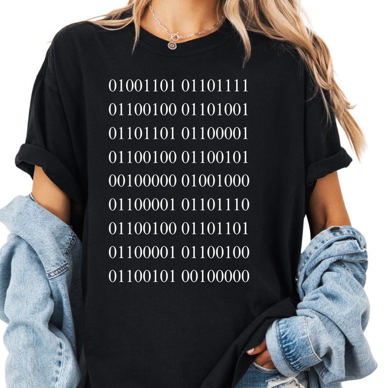 May include: Black t-shirt with white binary code text. The text reads "01001101 01101111 01100100 01101001 01101101 01100001 01100100 01100101 00100000 01001000 01100001 01101110 01100100 01101101 01100001 01100100 01100101 00100000".
