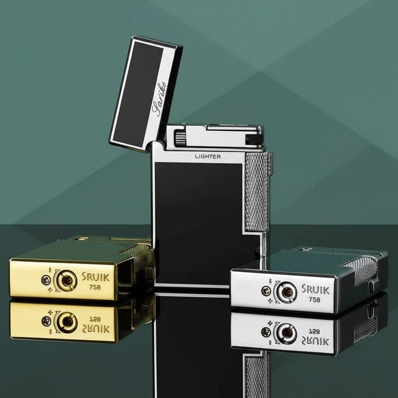 May include: A selection of elegant lighters in gold, silver, and black. The central lighter is open, displaying a black and white interior. The lighters are rectangular with the text "Lighter" and "Sruik 758" visible.