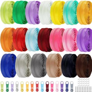Puede incluir: Una colección de cremalleras de colores en varios tonos, incluyendo verde, morado, blanco, amarillo y azul. Las cremalleras están enrolladas y se muestran junto con tiradores y topes metálicos a juego. Ideal para proyectos de costura y manualidades.