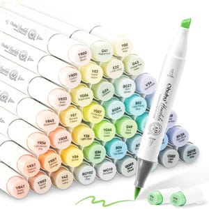 May include: A selection of Ohuhu Honolulu dual-tip art markers in a range of colours, neatly arranged. The markers have white barrels and colour-coded caps, with the brand name and "AP" certification visible. One marker is shown with its green chisel tip.