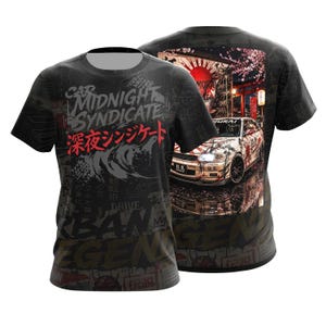 Pode incluir: Uma t-shirt preta de manga curta com uma impressão gráfica de um carro branco com detalhes vermelhos, flores de cerejeira e um sol vermelho. A frente exibe o texto "CAR MIDNIGHT SYNDICATE" em branco e "深夜シンジケート" em vermelho, com "URBAN LEGEND" abaixo.