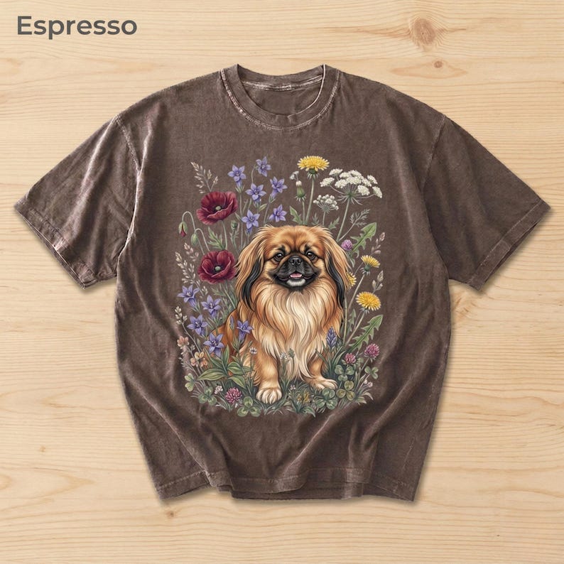 May include: Espresso-colored t-shirt featuring a detailed illustration of a Pekingese dog surrounded by colorful flowers. The dog has long, flowing fur and is smiling. The flowers include red poppies, purple blooms, and yellow dandelions. The word "Espresso" is at the top.