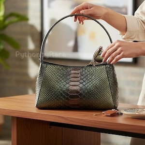 Könnte beinhalten: Ein Set aus drei Keramikbechern mit gesprenkelter, matter Oberfläche. Die Becher sind in Creme-, Hellgrau- und Dunkelgrautönen gehalten. Jeder Becher hat ein schlichtes, minimalistisches Design.