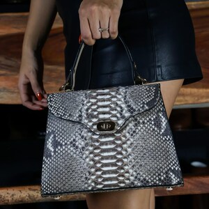 Op de afbeelding: Set van drie keramische mokken met een gespikkelde, crèmekleurige glazuur. Elke mok heeft een handgeschilderd bloemmotief in blauw, groen en geel. De mokken hebben een eenvoudige, afgeronde vorm en een handvat.