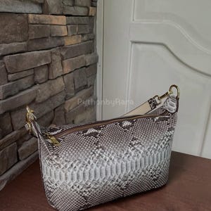 Könnte beinhalten: Eine weiße Keramik-Tasse mit schwarzem Henkel und dem handgeschriebenen Text "But First, Coffee". Die Tasse steht auf einer weißen Oberfläche. Für Heißgetränke geeignet.