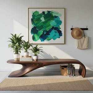 May include: A modern living room scene featuring a dark wood bench with a unique curved design. Three potted plants sit on the bench, with a framed abstract painting above. A woven rug and a basket add texture to the space.