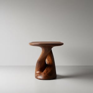 May include: A handcrafted wooden side table with a unique, sculptural design. The table features a round top and a twisted, hourglass-shaped base. The wood has a rich, dark brown colour and visible grain.