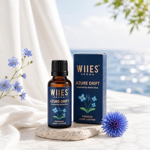 Può includere: Un flacone in vetro marrone e una scatola rettangolare blu scuro di olio profumato Wiies Aroma Azure Drift. Entrambi presentano testo dorato, un grafico a fiore blu e le parole Premium Long Lasting. Il flacone ha un tappo nero e poggia su una pietra.