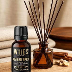 May include: A brown glass bottle of WIIES Aroma Amber Spice essential oil with a black cap, next to a small brown glass diffuser bottle with brown reeds. The label reads "Inspired by Cinnamon Ginger" and "Premium Long Lasting."