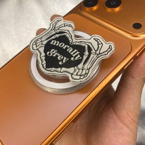 May include: A set of three ceramic mugs with a speckled, cream-colored glaze. Each mug features a different hand-painted floral design in shades of blue, green, and yellow. The mugs have a simple, modern shape.