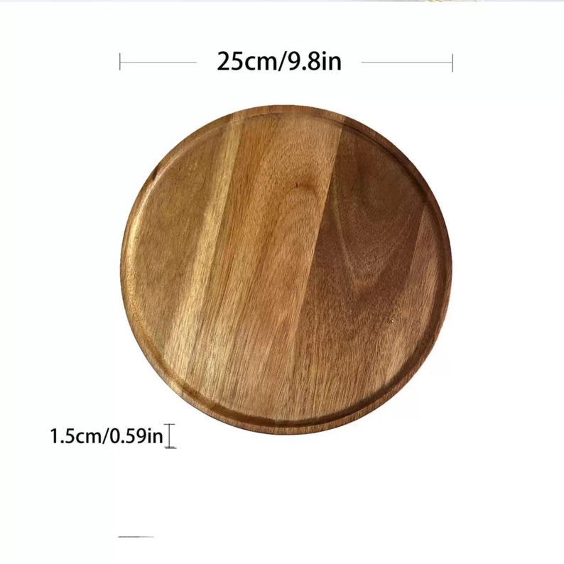 May include: A round wooden serving tray with a natural wood grain finish. The tray is 9.8 inches in diameter and 0.59 inches thick. The tray has a slightly raised edge and is suitable for serving food or displaying items.