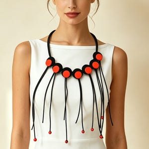 Wyrazisty czerwono-czarny geometryczny naszyjnik z minimalistycznym frędzlem, nowoczesna, lekka i szykowna biżuteria