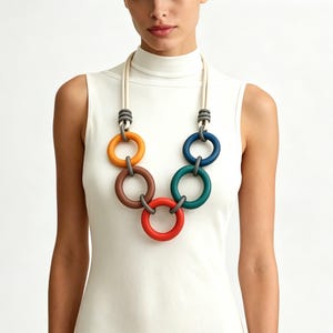 Puede incluir: Una taza de cerámica blanca con un asa negra y el texto "But First, Coffee" en negrita negra. La taza está llena de un líquido oscuro, probablemente café, y se encuentra sobre una superficie clara.