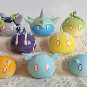 Puede incluir: Un juego de tres tazas de cerámica con un acabado mate moteado. Las tazas son de color crema, gris claro y gris oscuro. Cada taza tiene un diseño simple y minimalista.