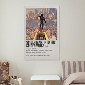 May include: A framed poster for the animated film "Spider-Man: Into the Spider-Verse" (2018). The poster features Spider-Man leaping over a yellow structure with a cityscape backdrop. The title and credits are displayed in white text.