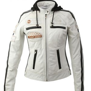 Pode incluir: Um blusão de motociclista branco com detalhes pretos, um capuz preto removível e um fecho central. O blusão apresenta vários emblemas bordados, incluindo um com a inscrição Speed Race, e riscas pretas ao longo do comprimento das mangas.
