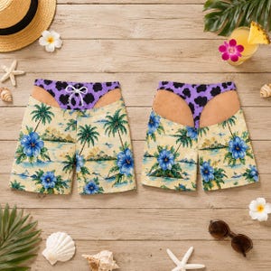 Può includere: Due paia di costumi da bagno con stampa tropicale di fiori di ibisco blu e palme verdi su sfondo giallo chiaro. La parte superiore di ogni costume presenta un motivo animalier viola e nero che ricorda un perizoma.