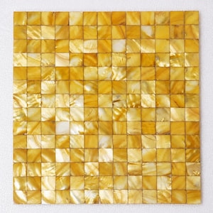 May include: A square mosaic tile sheet composed of small, individual square pieces of iridescent yellow mother-of-pearl. Each tile features a unique, natural grain pattern with varying shades of golden yellow, amber, and creamy white highlights.